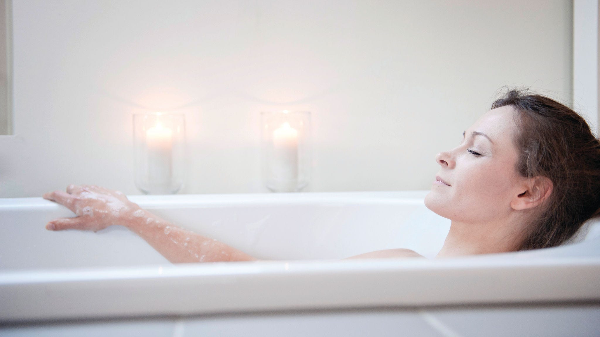 Femme se relaxant dans une baignoire contenant de l'eau chauffée avec de l'énergie renouvelable à l'aide d’un boiler thermodynamique.