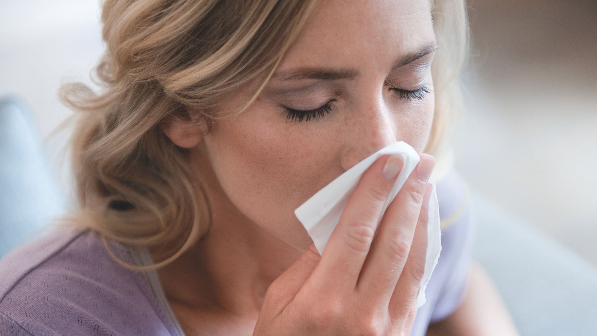 Femmes éternuant à cause d'allergies