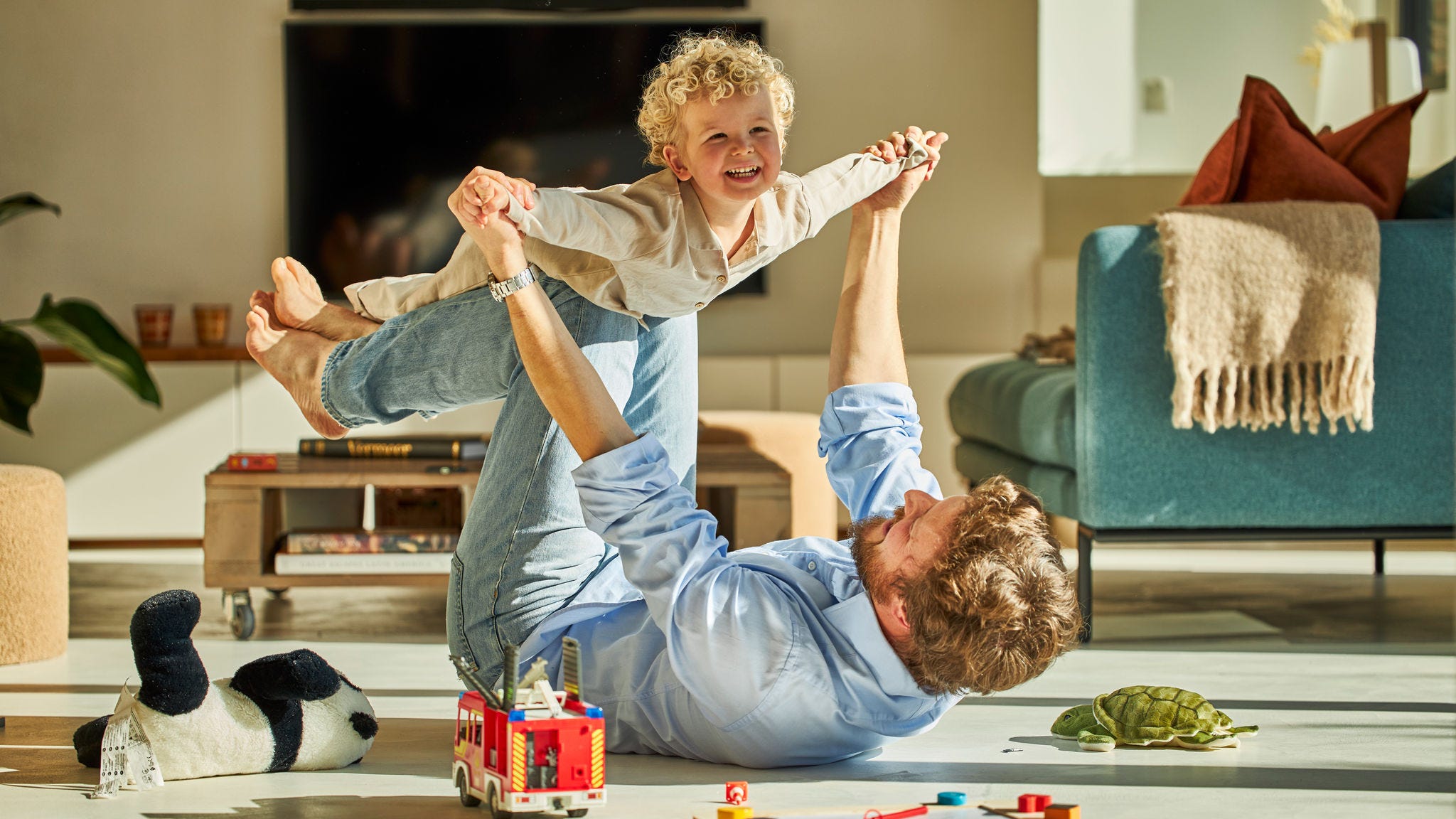 Vader en kind spelen gezellig samen terwijl ze van de warmte van de vloerverwarming genieten