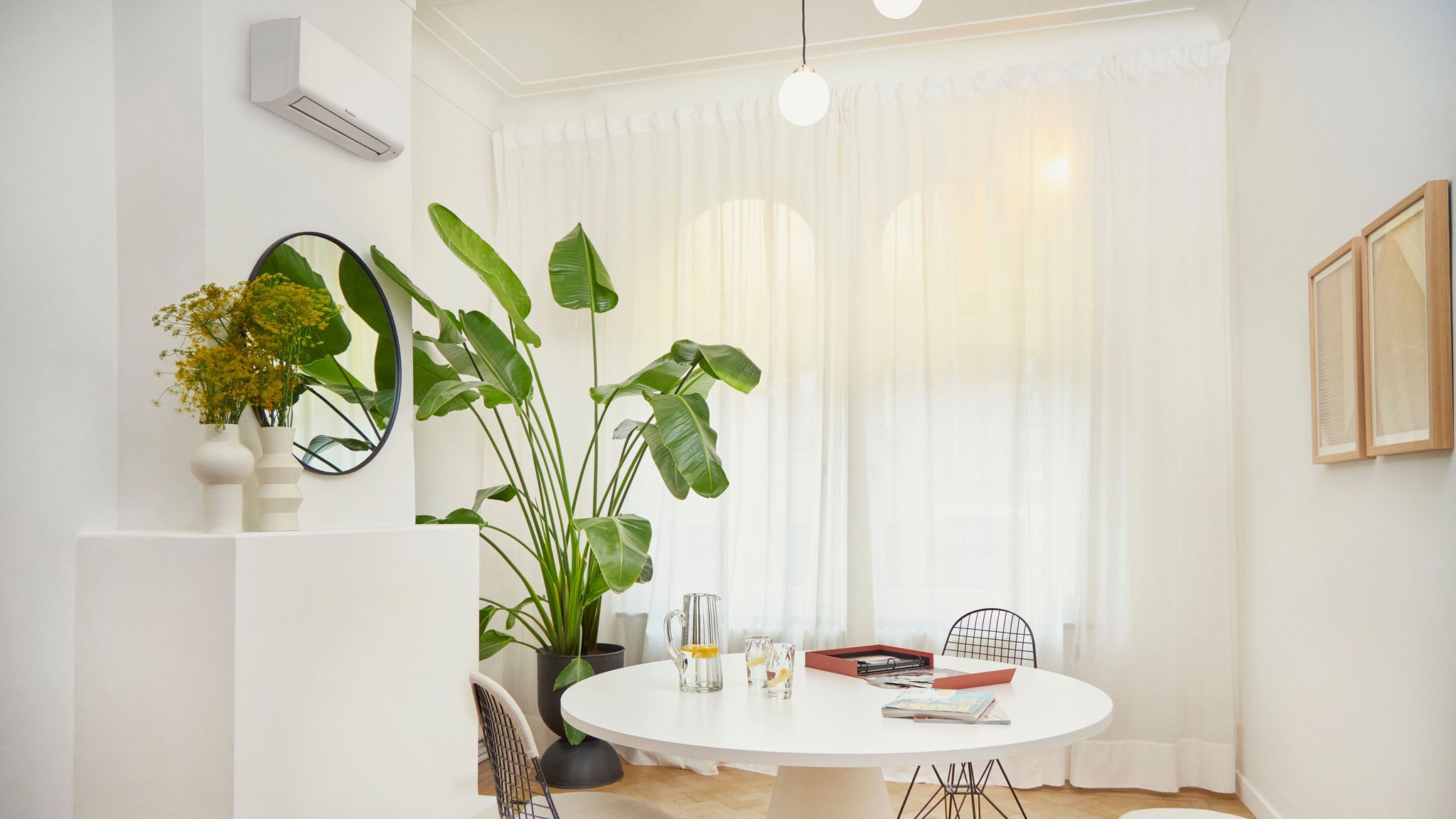 Witte woonkamer met fotoalbum op ronde tafel en planten