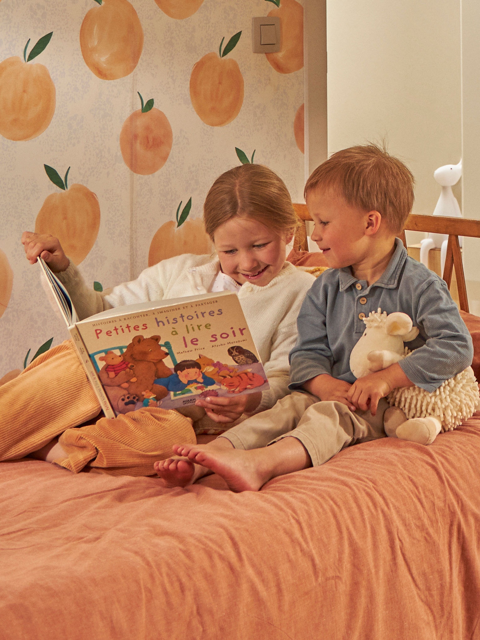 Enfants lisant un livre dans leur lit