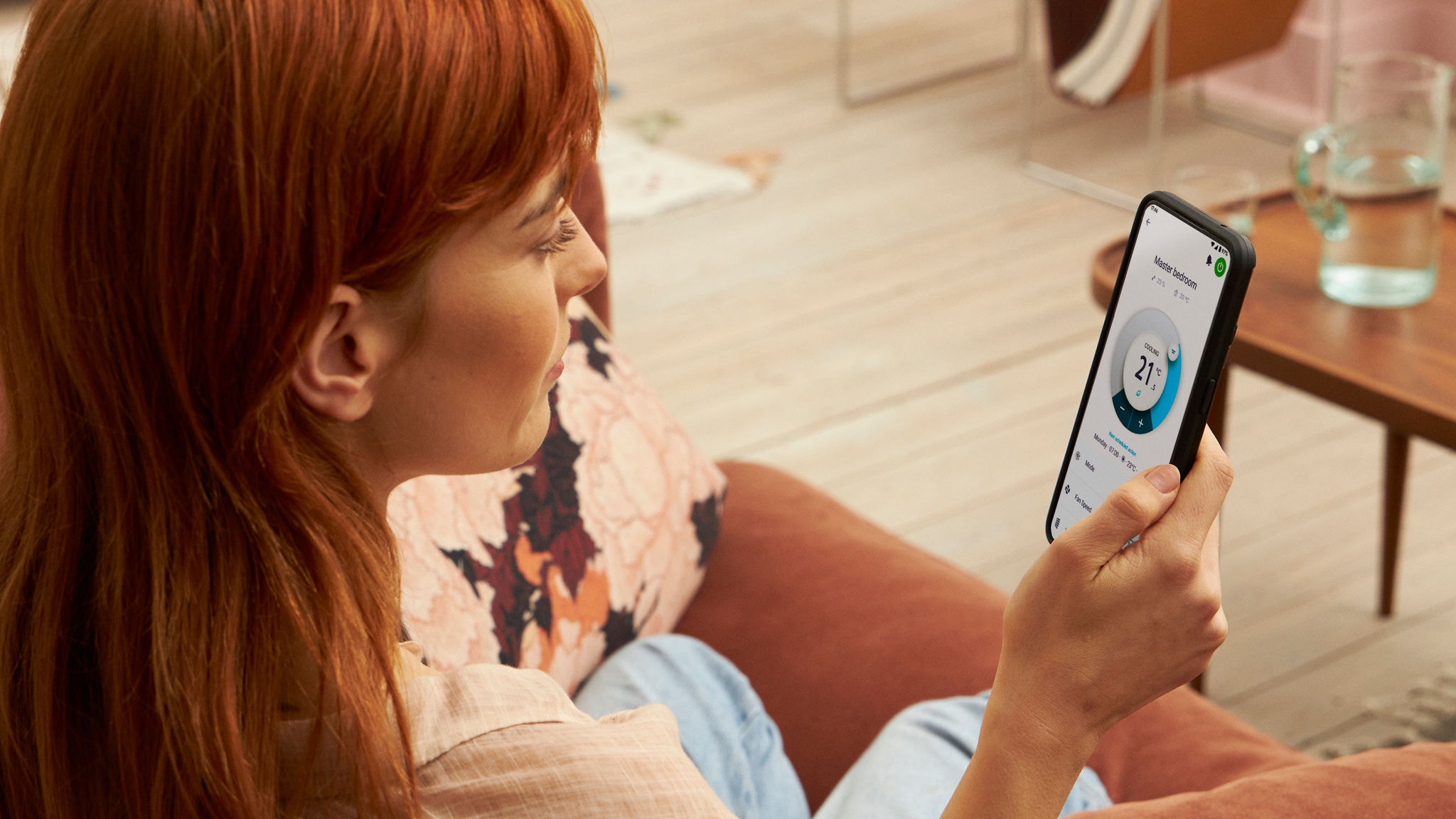 Een vrouw die de verwarming controleert met de Onecta-app