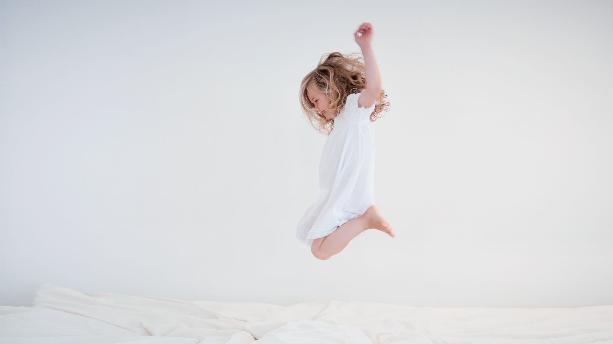 Enfant saute sur le lit dans sa chambre avec de l'air purifié grâce au purificateur d'air