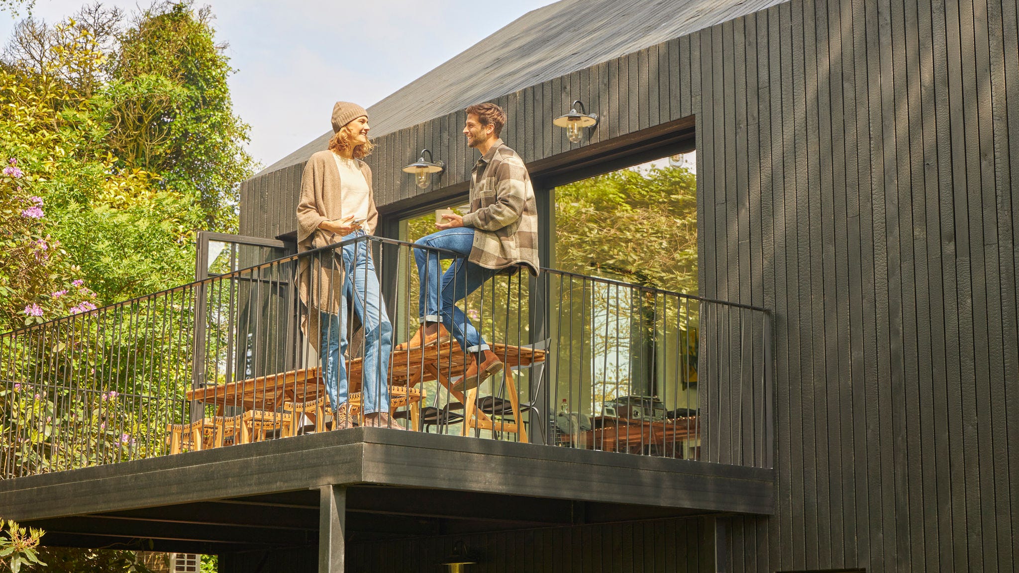 Couple discutant sur la terrasse d’un bungalow en pleine nature