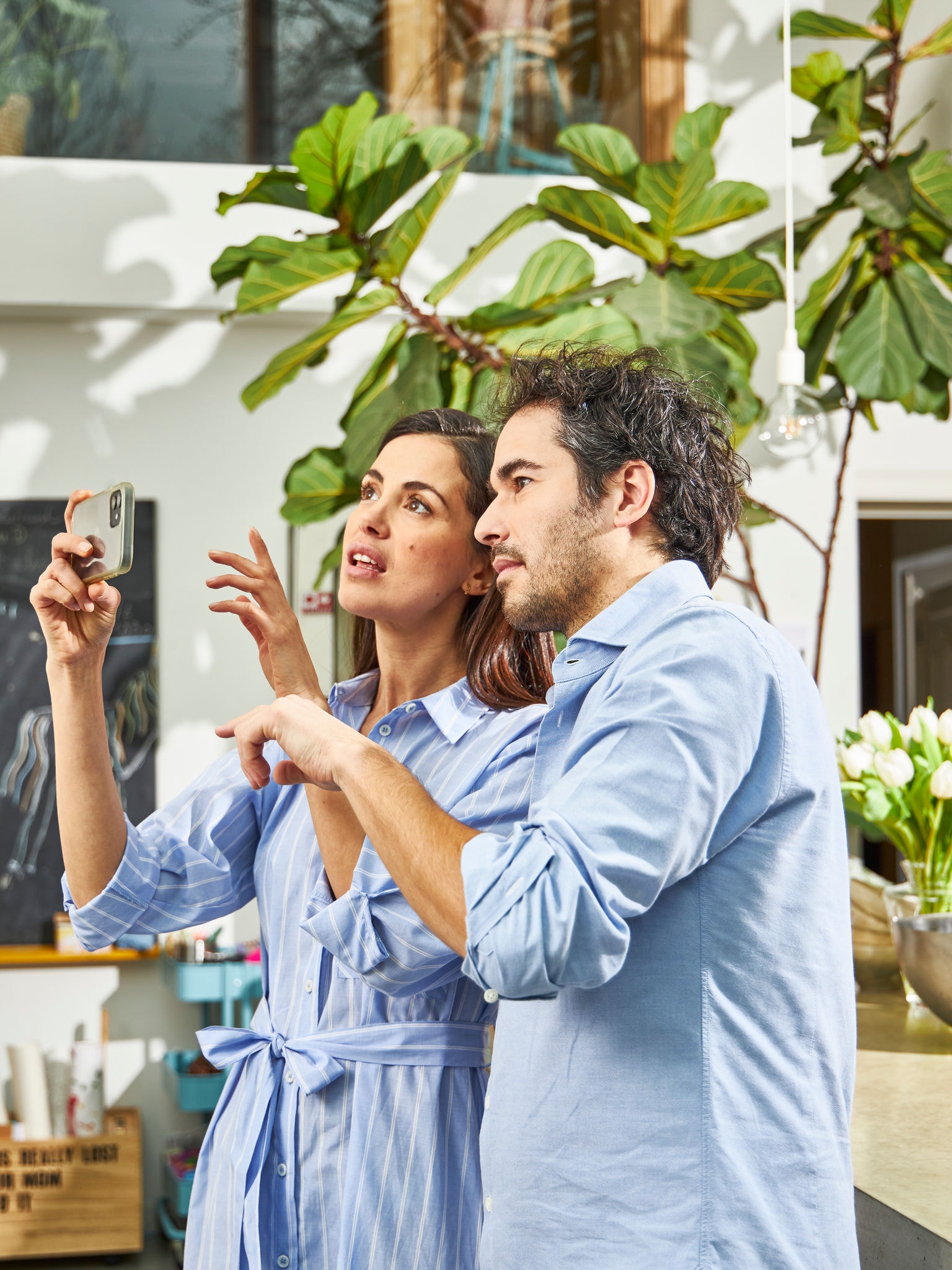 Couple utilisant l'application 3D avec des pompes à chaleur air- air à réalité augmentée pour visualiser les unités avec le design intérieur et extérieur.