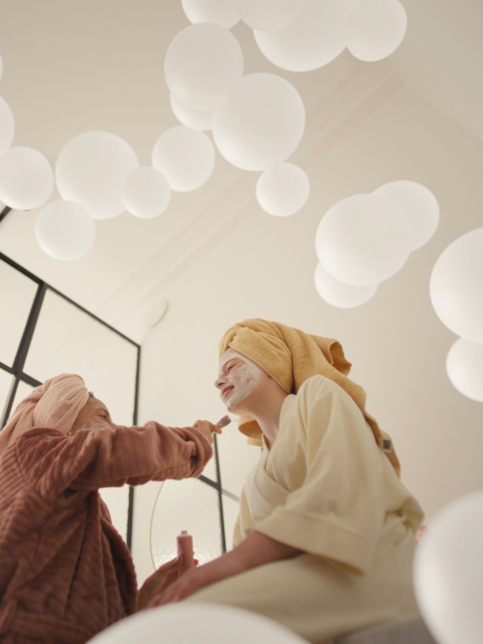 Moeder en dochter genieten van een gezichtsmasker in een goed geventileerde kamer, dankzij een ventilatiesysteem met verse lucht