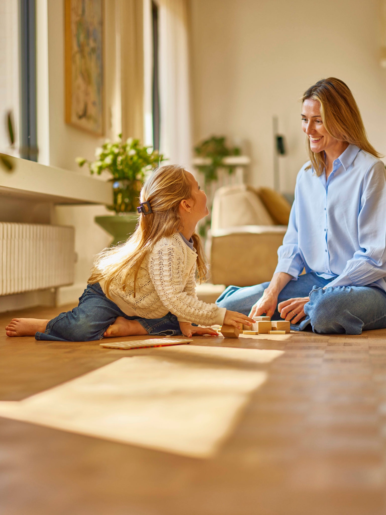 Mère jouant avec sa fille dans une pièce agréablement chauffée par un radiateur mural