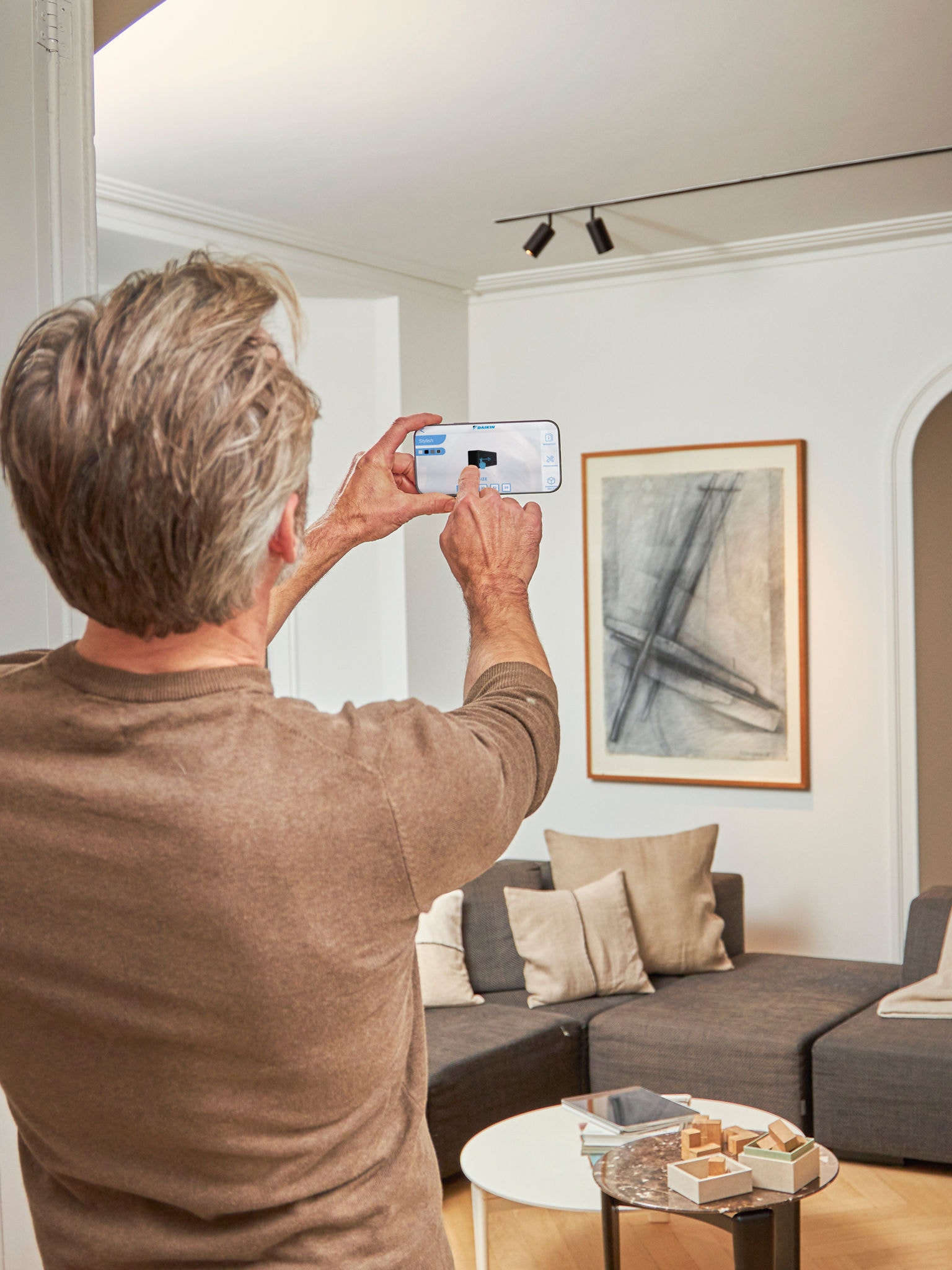 Een man gebruikt de 3D app met augmented reality om lucht/lucht warmtepompen te visualiseren binnen en buiten hun eigen woning