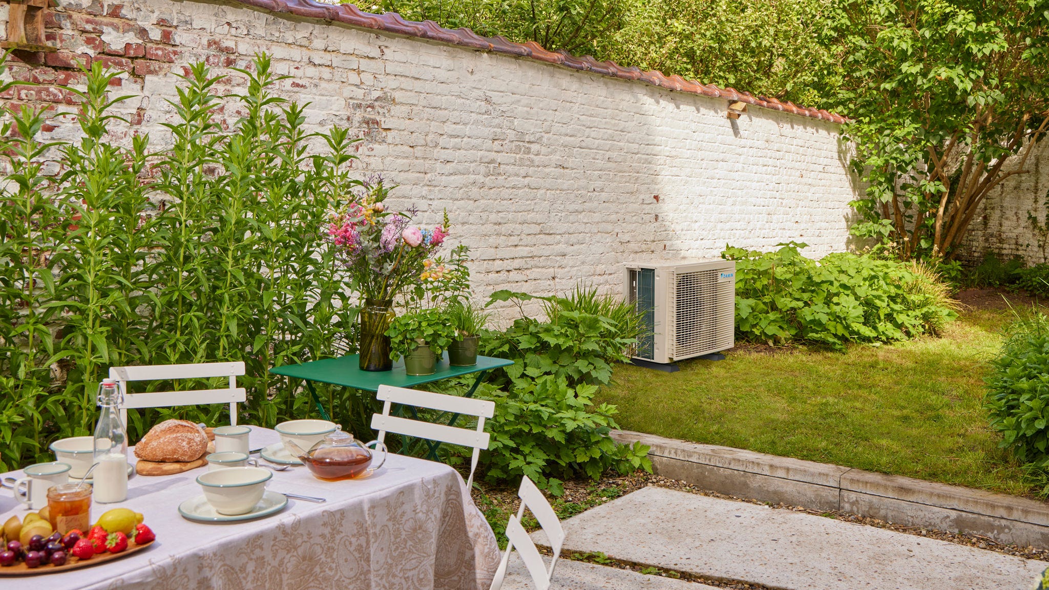 Ontbijt in de tuin, met een airco met inverter die de woning ernaast koelt