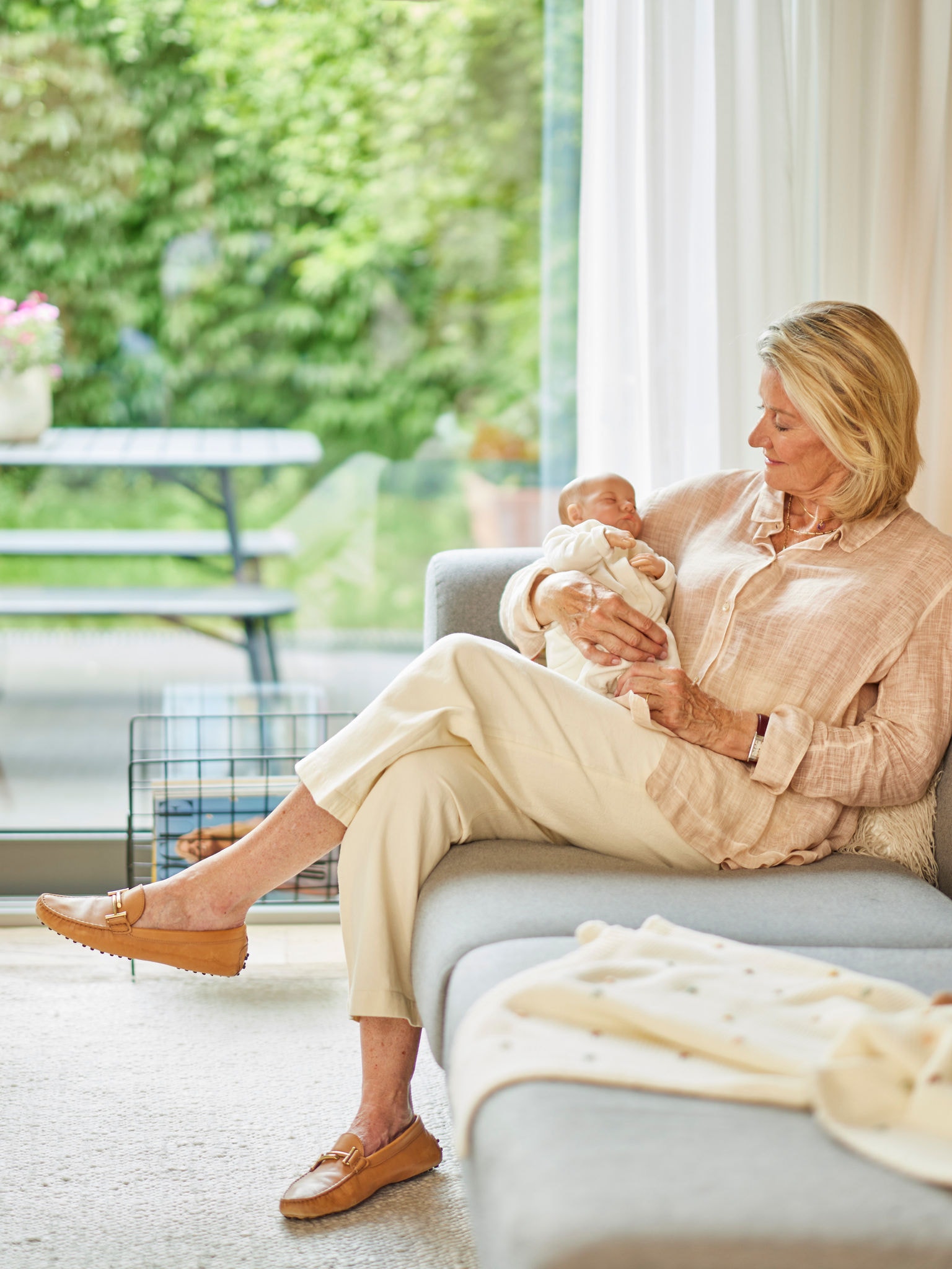 Een vrouw houdt een baby vast op een bank in een comfortabel verwarmde kamer.