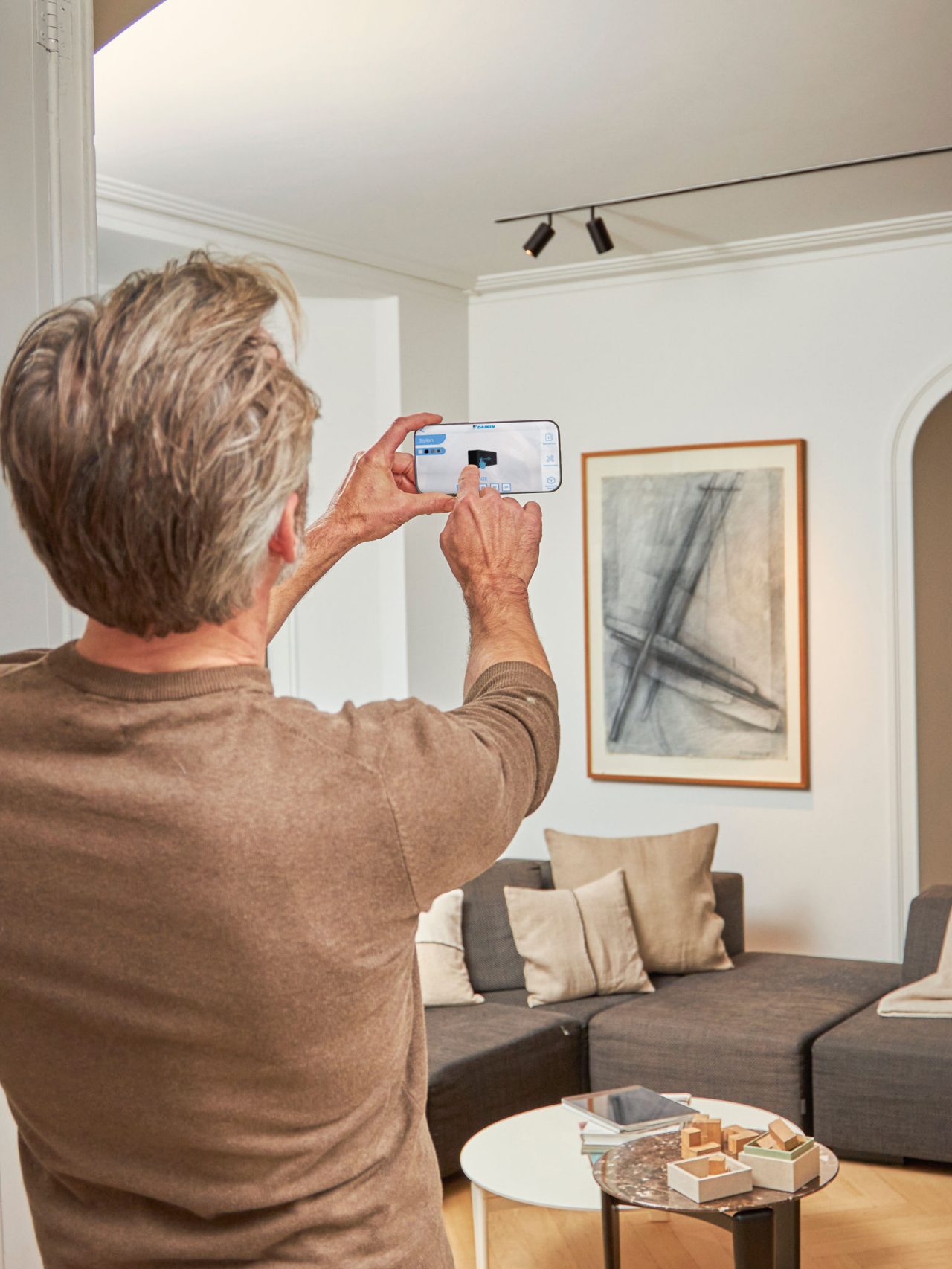 Homme utilisant une application pour commander sa solution de chauffage